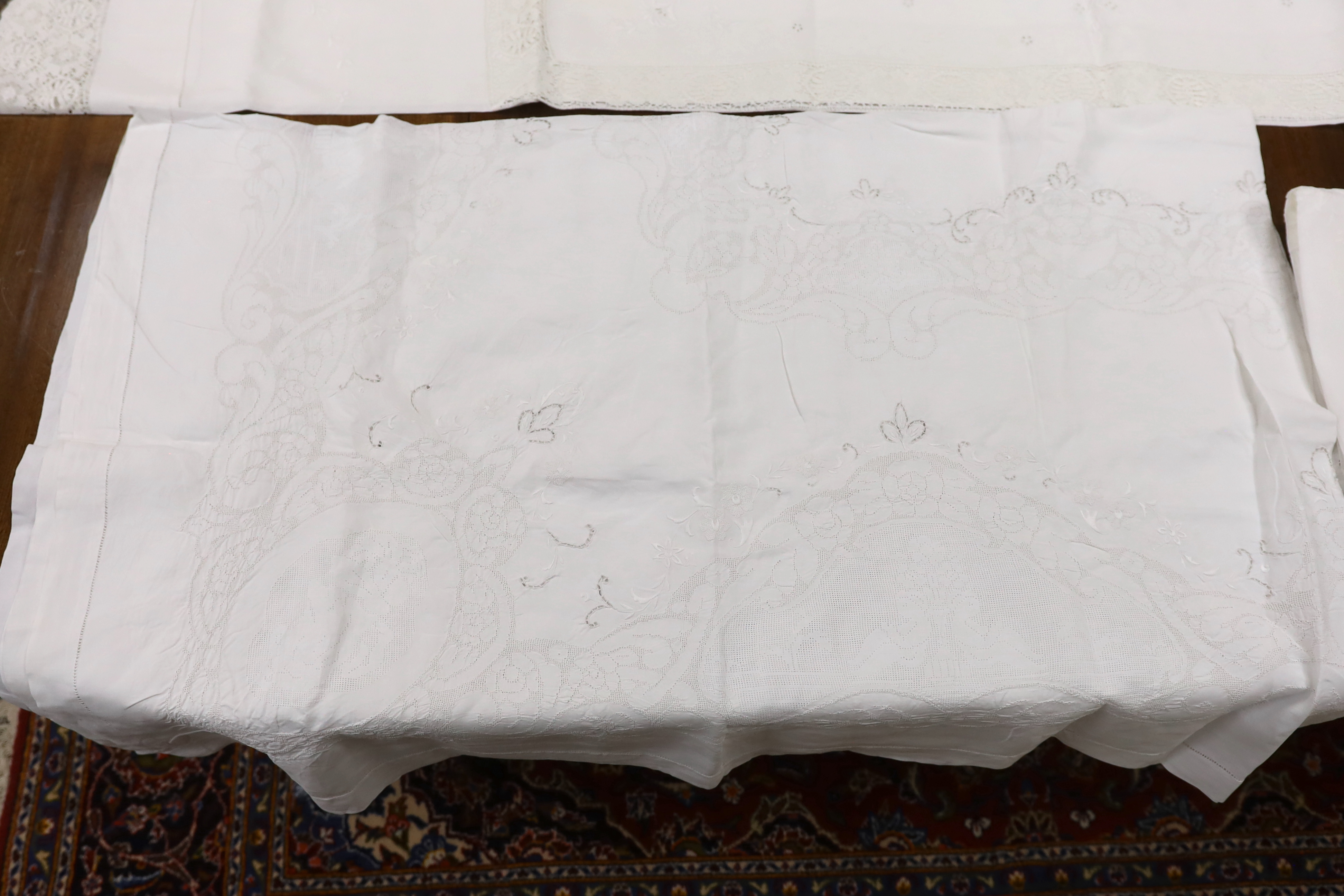 Table linen; A large linen embroidered and finely worked table cloth, an Anglaise worked cloth with crochet border and a fine appliqué cloth (3)